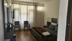 a bedroom with a bed and a table and chairs at Mcleodganj diaries Guesthouse in Dharamshala
