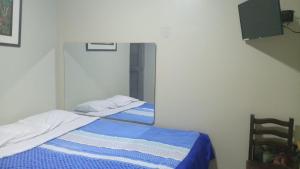 una camera da letto con due letti e uno specchio di Hospedaje El Encanto a Huancayo