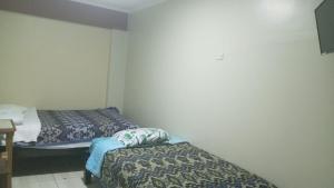 una stanza con due letti in una stanza di Hospedaje El Encanto a Huancayo