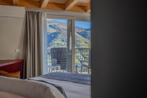 1 dormitorio con cama y vistas a la montaña en Miramontino Mountain Suite, en Rota d'Imagna
