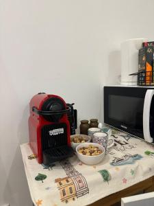 un grille-pain rouge posé sur une table avec un bol de nourriture dans l'établissement Cosy studio VIEUX NICE à 2 pas de la MER, à Nice