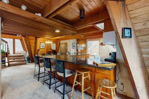 eine Küche mit einer Bar in einer Hütte mit Holzwänden in der Unterkunft Retro Family Gathering Home in Tahoe Donner in Truckee