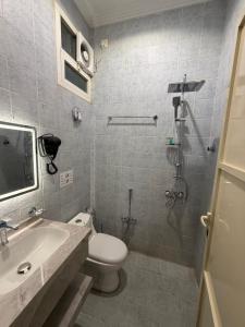 Un baño con inodoro, lavabo y ducha. en مدن هاوس ودخـول ذاتي, en Hail 11 fotos más