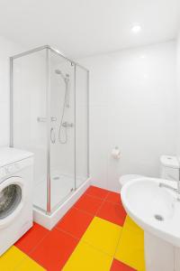a colorful bathroom with a shower and a washing machine at Білі апартаменти на Кельнському бульварі in Dnipro +3 photos
