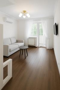 a white living room with a couch and a table at Білі апартаменти на Кельнському бульварі in Dnipro