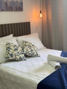 a bed with blue and white pillows on it at Makambira Residence no Centro de Porto de Galinhas in Porto De Galinhas +51 photos