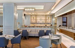 un restaurante con 2 mesas y sillas y un bar en Golden Tulip Kin-Oasis Kinshasa, en Kinshasa