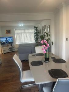 Una sala de estar con una mesa con flores. en Cassandra Homes, en Nevendon