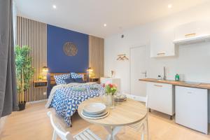 a bedroom with a bed and a table and a kitchen at Kazkle Etablissement in Boulogne-sur-Mer