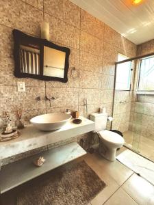 a bathroom with a sink and a toilet at Vale do Elefante - Casa com Jacuzzi e Cachoeira in Santana do Riacho