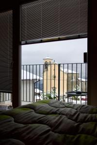 une chambre avec un lit et une vue sur un immeuble dans l'établissement Ca' Palmina - Appartamento con soppalco, à Ardenno