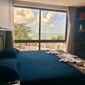 Un dormitorio con un gran ventanal con vistas a la playa. en Flat com vista linda para o mar!, en Cabedelo 34 fotos más