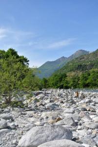 un gran grupo de rocas en un río en Rustico Di Vacanza Nel Nucleo Di Moghegno, en Moghegno