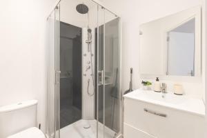 a white bathroom with a shower and a sink at Kazkle Etablissement in Boulogne-sur-Mer