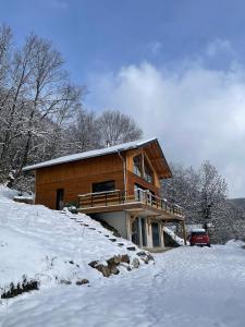 a log cabin in the snow with a car parked in front at Chalet vue panoramique in Fillinges