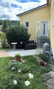 巴特武尔察赫Ferienwohnung Wiesenblume的一个带长凳、桌子和鲜花的院子