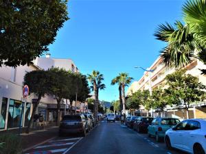 eine Stadtstraße mit parkenden Autos und Palmen in der Unterkunft Appartement T2 climatisé à Cavalaire, parking privé, proche centre et plages, balcon au calme - FR-1-226B-110 in Cavalaire-sur-Mer