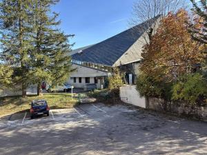 une maison avec une voiture garée sur un parking dans l'établissement Appartement fonctionnel avec balcons, parking et Wi-Fi - Centre de Villard de Lans - FR-1-548-19, à Villard-de-Lans