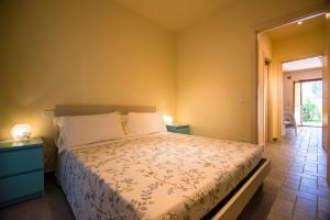 a bedroom with a bed and two tables and a window at Quadrilocale Stella in Alberese