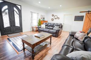 un soggiorno con un divano in pelle e un tavolo di Horse Farm, 4BR 4BA Lodge in Scenic Valley, 20min from Center Hill Lake, 1hr from Nashville 