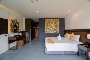 une chambre avec un grand lit blanc et une cuisine dans l'établissement Blue Beach Apartment, à Rawai Beach