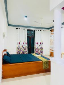 Un dormitorio con una cama con sábanas y cortinas azules. en Buono Villa, en Negombo