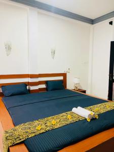 Un dormitorio con una cama con sábanas azules y almohadas azules. en Buono Villa, en Negombo