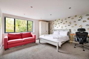 1 dormitorio con cama, sofá rojo y escritorio en Yonder, en Harley