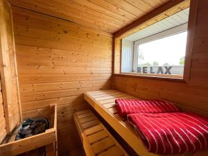 a small sauna with a window and a red blanket at villa kunterBUNT in Grödersby +25 photos