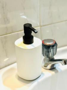 a soap dispenser sitting on top of a bathroom sink at Apartamento gourmet com quintal in Albufeira +37 photos