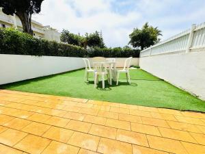 two chairs and a table on a lawn at Apartamento gourmet com quintal in Albufeira
