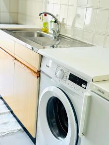 a washing machine in a kitchen with a sink at Apartamento gourmet com quintal in Albufeira
