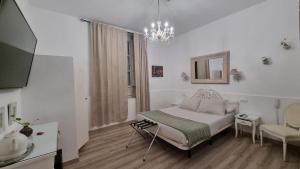 ein weißes Schlafzimmer mit einem Bett und einem Spiegel in der Unterkunft Un Patio al Sur in Sevilla + 75 Fotos