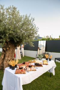 a table with food on it next to a tree at Vinea Rural Resort - Adults only in Arco