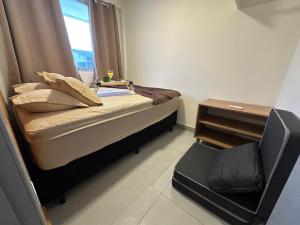 グァラトゥバにあるFlamingo Pé na areia - Centro/Guaratubaのベッドと窓のある小さな寝室