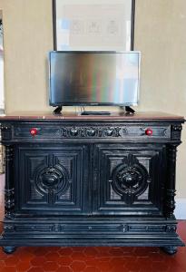 a black cabinet with a television on top of it at Les Chambres des Barques in Narbonne +18 photos
