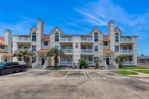 a large apartment building with a parking lot at Beach Club 323 in Padre Island