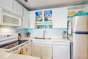 a kitchen with white cabinets and white appliances at Beach Club 323 in Padre Island