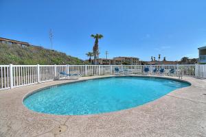 una piscina con sillas y una valla en Nelray Shores at Seamist Condominiums, en Port Aransas