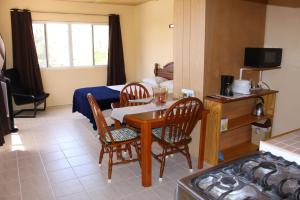 a room with a table and chairs and a bed at Esaw Place in Christ Church