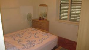 a bedroom with a bed with a dresser and a mirror at Holiday House in Sušica