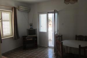 a living room with a tv and a table and window at Holiday House in Sušica