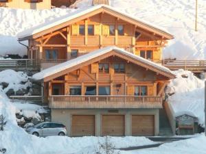 ein großes Holzhaus mit Schnee auf dem Boden in der Unterkunft Triplex 8 pers. en Chalet Traditionnel, Pied des Pistes, Terrasse, Balcon, Parking - FR-1-458-164 in Le Grand-Bornand