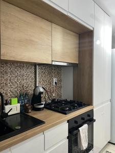 克拉约瓦Beatrice Residence Centru Vechi的厨房配有白色橱柜和炉灶烤箱