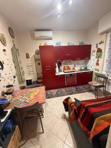 cocina con armarios rojos, mesa y sillas en zena, en Génova