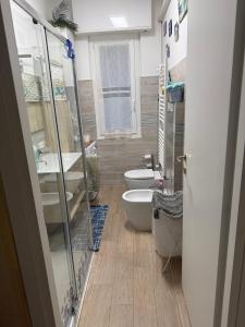 Un baño con dos inodoros, un lavabo y una bañera. en zena, en Génova