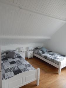 - 2 lits dans une chambre dotée de plafonds blancs dans l'établissement Traumhaftes-freistehendes-Ferienhaus-an-der-See-Strand-Yachthafen-W-Lan, à Bruinisse