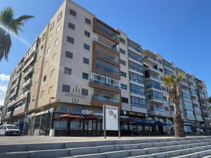 a large building on a street with a palm tree at Studio Stadium morocco for family in Mohammedia