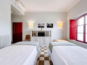 two beds in a white room with red curtains at RICASOLI, Brolio Agriroom in Gaiole in Chianti +25 photos