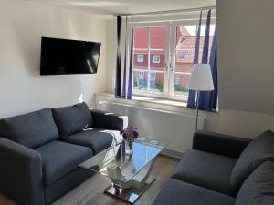 a living room with two couches and a glass table at Seaside-Amrum-11 in Norddorf